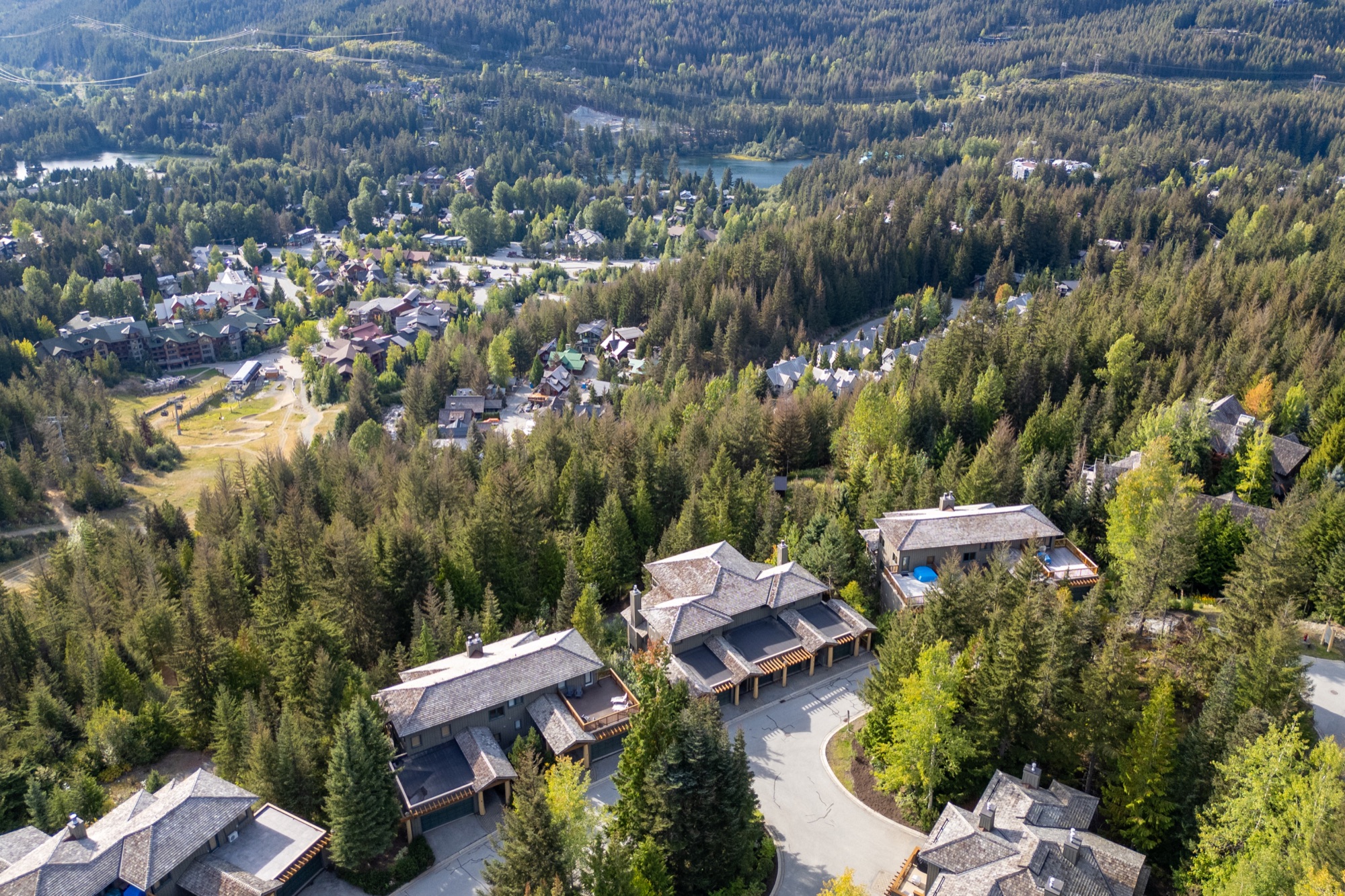 Aerial view of a Whistler neighbourhood surrounded by forest, lakes, and mountains