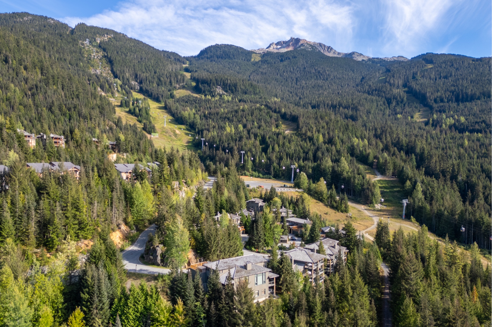 Aerial view of Whistler homes beneath the ski slopes and surrounding mountains